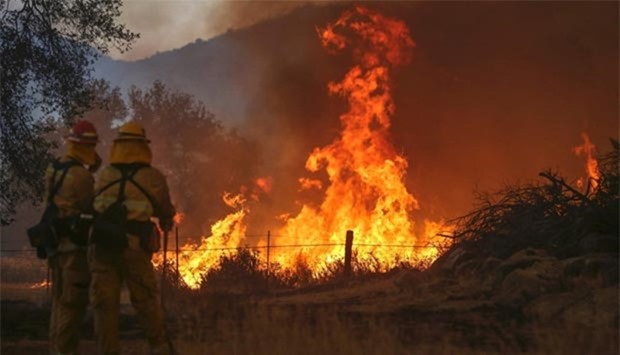 Firefighters watch a backfire flare up in eastern San Diego county