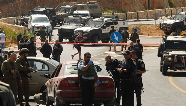 Israeli security forces gather at the scene of a reported a car-ramming attack at the entrance to the settlement of Kiryat Arba, near the West Bank city of Hebron.