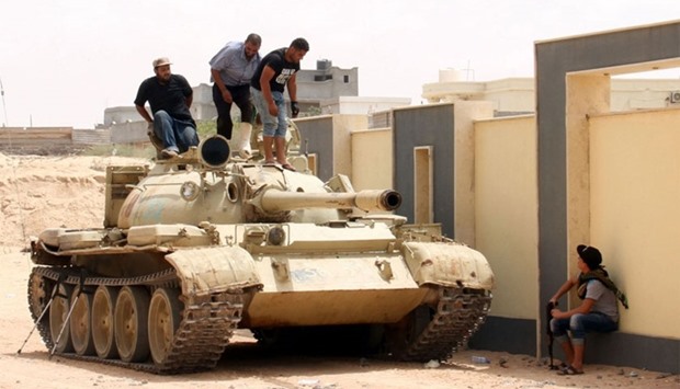 Fighters from the pro-government forces loyal to Libya's Government of National Unity (GNA) stand on a tank as they target the Islamic State (IS) group in Sirte with a wave of air strikes to help pave the way for ground troops to take the jihadists' coastal stronghold.