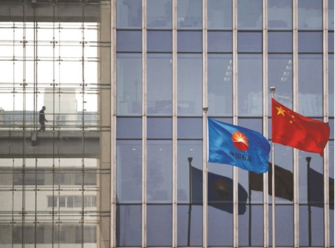 PetroChinau2019s flag flutters next to a Chinese national flag at its headquarters in Beijing. Saudi state oil firm Aramco is looking to invest $1bn-$1.5bn in the refinery as well as the retail assets of the Chinese firm, sources said.