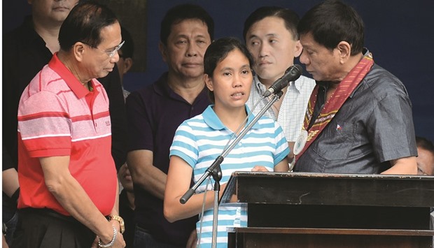 Philippinesu2019 president-elect Rodrigo Duterte talks to released hostage Marites Flor (centre) while incoming Peace process secretary Jesus Dureza (left) looks on, as Duterte attended a turn-over ceremony of police officials in Davao City, in the southern island of Mindanao yesterday.