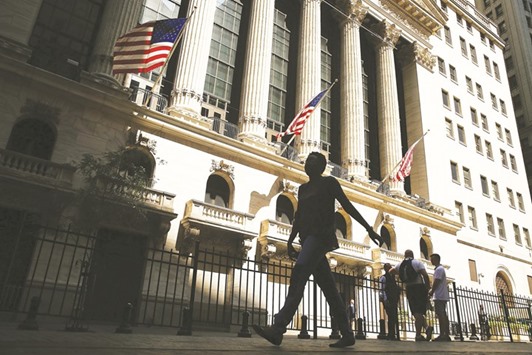 People walk by the New York Stock Exchange. Some of the biggest Wall Street banks opposed an industry decision to sue the US Labour Department over its new broker rules, exposing a fissure between the companies and their smaller competitors, people familiar with the matter said.