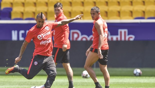Chileu2019s Arturo Vidal (left) kicks the ball as Alexis Sanchez (right) and Enzo Roco look on during a training session in Harrison, New Jersey, yesterday. (AFP)