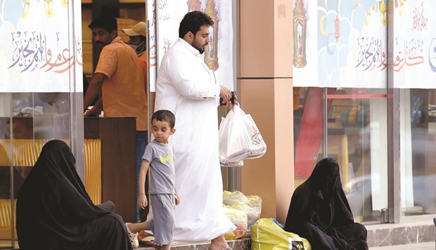 Women sitting and begging outside a supermarket on a main street in Riyadh. 