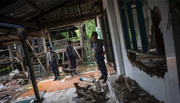 Police stand guard around the destroyed mosque at Thuye Tha Mein village in Bago province