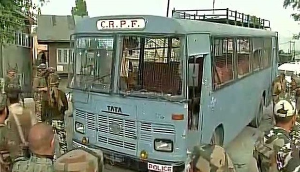 Security personnel stand guard near a damaged bus that was attacked by militants in Pampore, near Srinagar. (Photo tweeted by ANI)