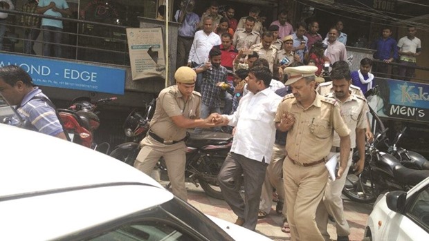 AAP legislator Dinesh Mohaniya argues with a policeman as he is taken to a waiting police car after his arrest yesterday.