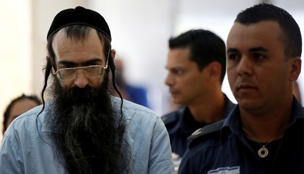 Yishai Schlissel (L), convicted of killing a woman during the 2015 Jerusalem Gay Pride Parade, is escorted by security personnel before he is sentenced at the Jerusalem District Court