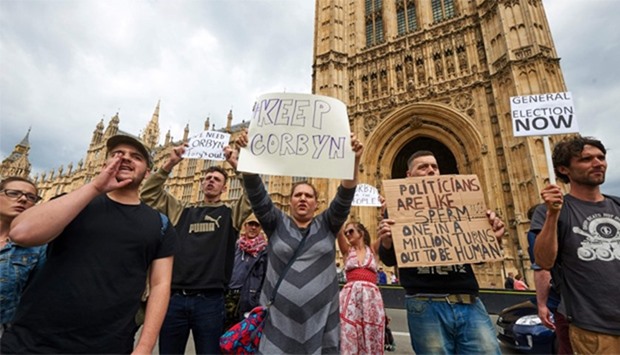 Demonstrators hold up placards as they protest outside the British Parliament in central London