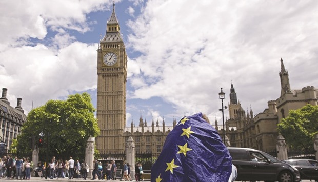 A demonstrator draped in an EU flag sitting on floor during a protest against the outcome of the UKu2019s June 23 referendum on the European Union, in central London.