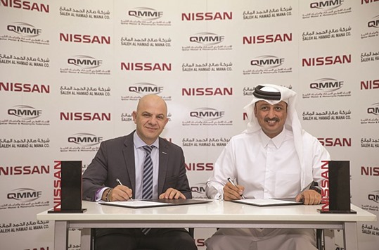 Nissan Middle East managing director Samir Cherfan (left) signs the sponsorship agreement with Qatari driver Adel Hussein Abdulla.