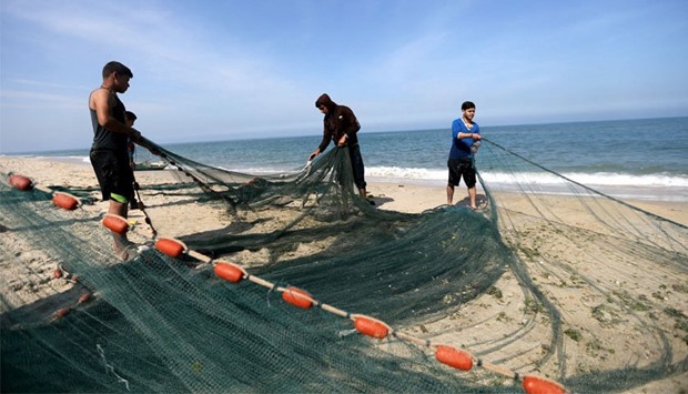 Gaza fishermen fix the nets on a boat as they start fishing off the coast of the Gaza Strip. April 3, 2016 File picture