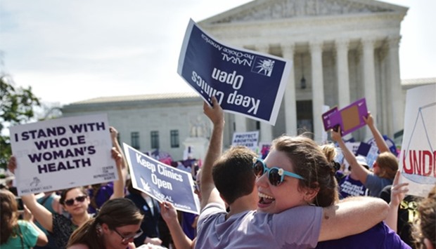 Abortion rights activists embrace after the US Supreme Court struck down a Texas law placing restrictions on abortion clinics