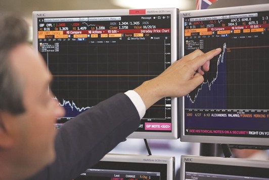 A trader from ETX Capital points to a Bloomberg terminal showing the FTSE 100 index in London. The index fell 2.6% to 5,982.20 points, taking total losses to 5.6% in two sessions and wiping off nearly u00a3100bn ($132bn) since the referendum results early on Friday.