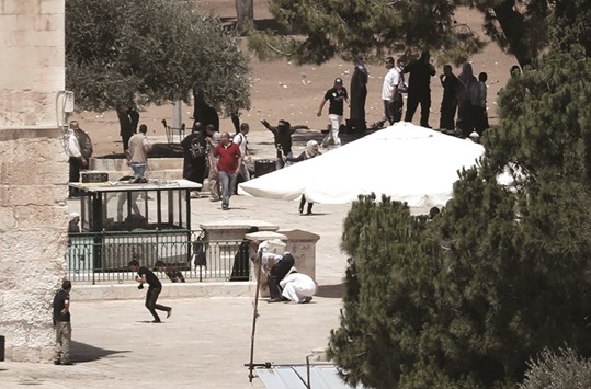 Palestinian worshippers run to take cover as Israeli police shoot rubber bullets towards Muslim protesters (unseen) barricaded inside Jerusalemu2019s Al-Aqsa mosque during clashes between Israeli police and Muslims protesting Jewish visits to the site during the holy month of Ramadan yesterday.