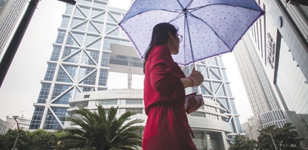 A pedestrian carrying an umbrella walks past the Shanghai Stock Exchange building in Shanghai. For the first time in at least a decade, Chinau2019s oldest bourse has lost its position at the top of turnover rankings for the nationu2019s four major trading venues.