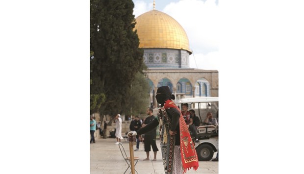 A masked Palestinian protester wearing pieces of cloth around his body keeps watch following clashes with Israeli police at Jerusalemu2019s Al-Aqsa mosque compound for the third consecutive day yesterday in Jerusalemu2019s Old City.
