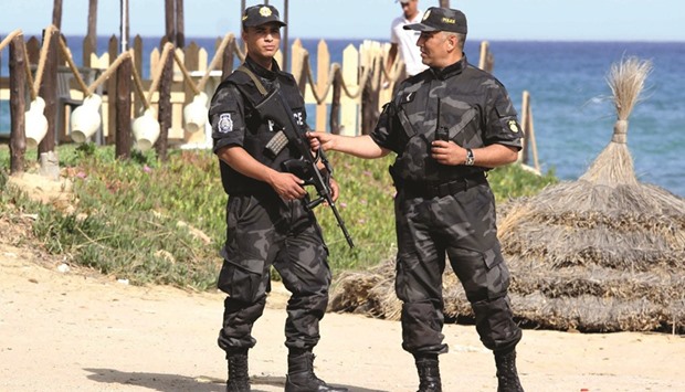 Tunisian policemen stand guard at a beach in the coastal resort of Hammamet, some 60km south-east of Tunis. Tunisian authorities and hotel managers hope improved security will help to win back the trust of holidaymakers on the first anniversary of the militant attack that killed 38 tourists at a beach resort.