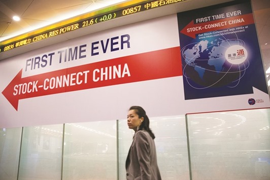 A woman walks past a banner reading u2018First Time Ever, Stock-Connect Chinau2019 during the launch ceremony of the Shanghai-Hong Kong Stock Connect at the Hong Kong Stock Exchange (file). The link between the Shanghai and Hong Kong stock exchanges has to date enabled southbound outflows that are 39% more than the amount thatu2019s moved north.