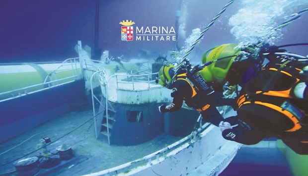 A photo released yesterday by the Italian Navy shows divers near the wreck of a fishing boat that sank in the Mediterranean sea on April 18, 2015