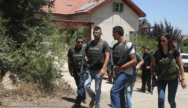 Israeli policemen walk outside a house in the Jewish settlement of Kiryat Arba in the occupied West Bank where a 13-year-old Israeli girl was fatally stabbed in her bedroom on June 30, 2016.