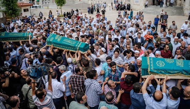 People carry the coffins of victims that were killed by the suicide bombing