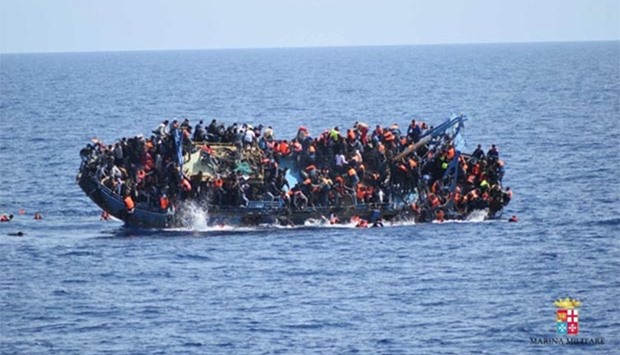 Migrants are seen on a capsizing boat before a rescue operation by Italian navy ships ,Bettica, and ,Bergamini, off the coast of Libya last week.