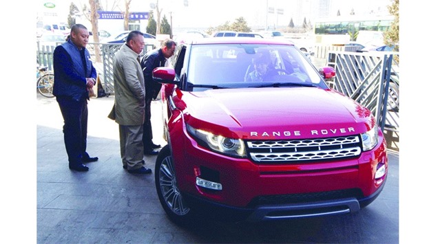 Customers look at a Range Rover Evoque car outside a dealership in Beijing. Jaguar Land Rover sales fell by a fifth in China in January-March of last year - when it launched its China-made Evoque u2013 after rising 36% in the same 2014 period.
