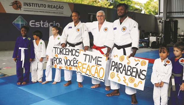 Judo athletes Yolande Bukasa (fourth from left) and Popole Misenga (third from right), refugees from Democratic Republic of Congo, pose with their coach Geraldo (centre) and children, during a news conference in Rio de Janeiro yesterday. (Reuters)