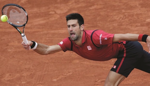Novak Djokovic goes for a return against Dominic Thiem during their French Open semi-final clash yesterday. Djokovic won 6-2, 6-1, 6-4 and will meet Andy Murray, who saw off defending champion Stan Wawrinka in the other semi-final, in tomorrow's final. (Reuters)