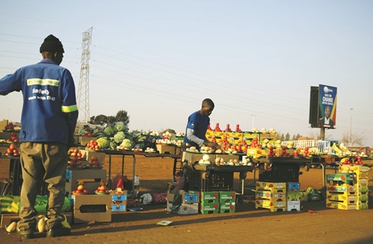 A roadside vendor sorting his wares as a customer waits in Soweto, South Africa, yesterday.