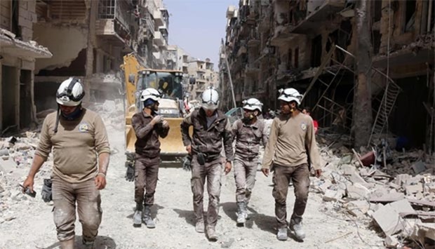 Syrian civil defence volunteers, known as the White Helmets, walk amidst the debris following a reported air strike by Syrian government forces in the rebel-held neighbourhood of Sukkari in the northern city of Aleppo on Friday.