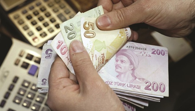 A money changer counts Turkish lira bills at a currency exchange office in Istanbul. Non-performing loans in Turkeyu2019s banking sector have been on a u201csignificantu201d rising trend as of late, Isbank has said.