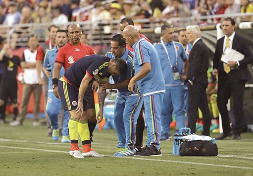 James Rodriguez #10 of Colombia is looked by the medical staff of Columbia during the Copa America match against USA.
