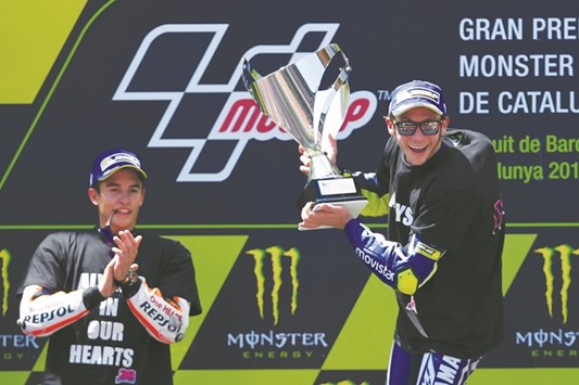 Second-placed Repsol Honda rider Marc Marquez (left) applauds first-placed Movistar Yamaha rider Valentino Rossi on the podium after the MotoGP race of the Catalunya Grand Prix at the Montmelo racetrack near Barcelona yesterday. (AFP)