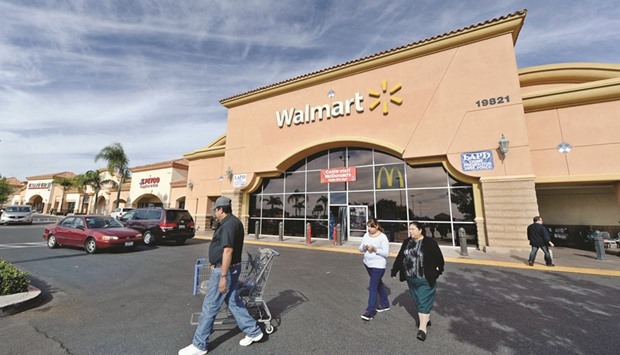 Customers walk outside a Wal-Mart store in Los Angeles (file). The retailer will begin testing the delivery of groceries using Uber and Lyft drivers, aiming to match the convenience of services offered by Amazon.com and other e-commerce companies.