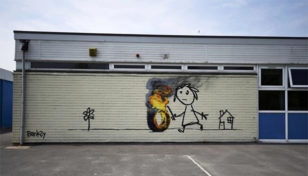 A mural, attributed to graffiti artist Banksy, is seen painted on the outside of a class room at the Bridge Farm Primary School in Bristol.