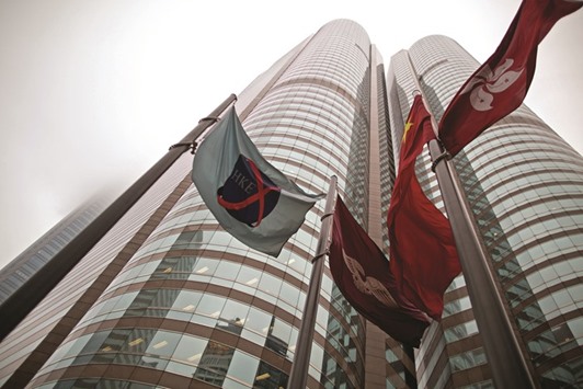 The flag of the Hong Kong Exchanges and Clearing (left) flies from a mast outside the stock exchange buildings in Hong Kong. The HKEx is facing a challenge to its plans to allow customers to trade in the Chinese bond market as the countryu2019s central bank offers access to international investors.