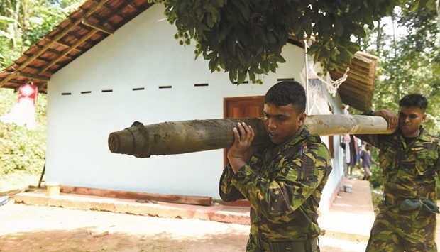 Sri Lanka Special Task Force soldiers carrying a multi-barrel rocket launcher at Salawa, on the edge of the capital Colombo yesterday, a day after an explosion at an ammunition depot at the neighbouring military complex.