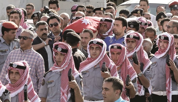 Jordanian mourners carry the body of intelligence corporal Omar al-Hayari, one of the five Jordanian intelligence agents killed during a gun attack at the Palestinian refugee camp of Baqaa, yesterday during his funeral in Salt, a town west of the capital Amman.