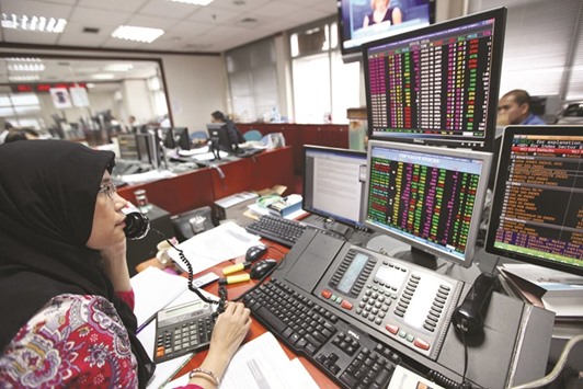 A trader works in front of computer monitors at a securities brokerage in Jakarta. The Jakarta Construction Property and Real Estate Index has jumped 6.4% from a two-month low on May 10.