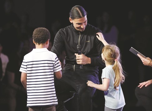 Swedish player Zlatan Ibrahimovic (centre) is congratulated by two children at the end of his press conference for the presentation of his sportswear brand A-Z in Paris yesterday. (AFP)