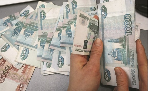 An employee counts rouble banknotes at a private shop selling home appliances in Krasnoyarsk. The rouble has appreciated almost 15% against the dollar this year after a 20% loss in 2015.