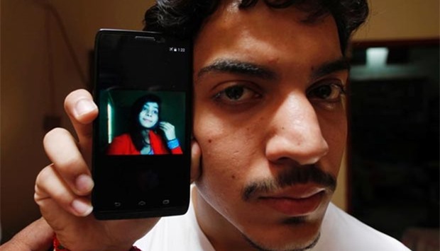 Hassan Khan shows the picture of his wife Zeenat Bibi, who was burnt alive by her mother, on his cellphone at his residence in Lahore.