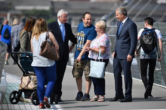 Former prime ministers John Major and Tony Blair speak to members of the public as they walk across the Peace Bridge, during a visit to share a platform for the Remain campaign event at the University of Ulster in Londonderry.