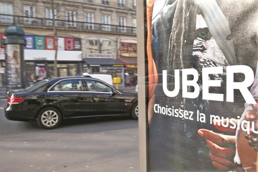 A taxi driving by an advertisement for the Uber car and ride-sharing service displayed on a bus stop in Paris. The companyu2019s problems in Europe have led it to shift its focus to its service staffed by professional drivers in black sedans, which has grown rapidly in France and now employs about 10,000 drivers.
