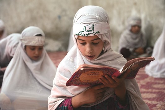 Afghan girls recite the Holy Quru2019an at a Madrassa during the month of Ramadan in Kandahar yesterday.