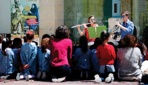 Two musicians perform in front of Palestinian schoolchildren during a festival organised by Palestinian musician Ramzi Aburedwan.