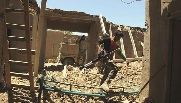 Afghan Border Police personnel walk through an outpost damaged in an airstrike in the Nad Ali district of Helmand province yesterday.