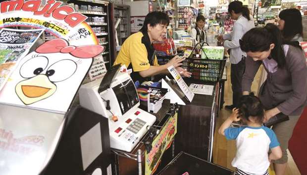 Shoppers line up in front of cashiers at the Don Quijoteu2019s central branch store in Tokyo. Bank of Japan governor Haruhiko Kuroda said the country had escaped from deflation but still had more progress to make before reaching its goal for 2% inflation.
